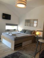a bedroom with a large bed and a television at Luma 2 in Osijek