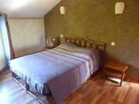 Schlafzimmer mit einem Bett und Holzboden in der Unterkunft Villa Flamboyant in Le Portail