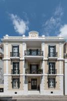 a white building with balconies and a clock on it at The Anthemion House in Kavala