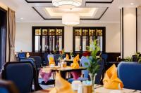 uma sala de jantar com mesas e cadeiras azuis em Laluna Hoi An Riverside Hotel & Spa em Hoi An