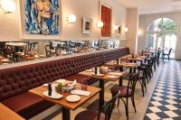 un restaurante con una fila de mesas y sillas en Steigenberger ICON Grandhotel & Spa Petersberg, en Königswinter