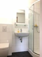 a white bathroom with a sink and a shower at Apart Pension Plaue in Brandenburg an der Havel
