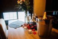 a table with two glasses of champagne and a vase with flowers at La Suite Romantique avec Jacuzzi au Cœur de Perpignan in Perpignan