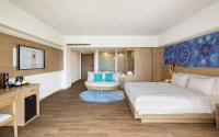a hotel room with a large bed and a table at Eastin Ashta Resort Canggu in Canggu