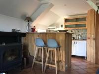 a kitchen with two blue bar stools and a stove at Le sentier des étangs in Barsy