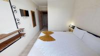 a bedroom with a white bed with a wooden headboard at Patron Hotel in Antalya