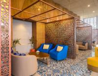 a lobby with blue chairs and a table at Eastin Ashta Resort Canggu in Canggu