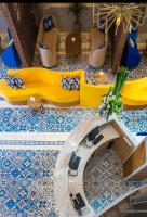 a lobby with yellow and blue tiled floors and a table at Eastin Ashta Resort Canggu in Canggu