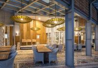 a restaurant with tables and chairs and chandeliers at Eastin Ashta Resort Canggu in Canggu