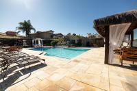 a patio with a swimming pool and chairs at Pousada Casa do Catavento in Búzios
