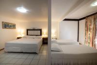 a bedroom with two beds and a window with two lamps at Pousada Casa do Catavento in Búzios