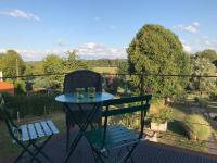 a table and chairs on a balcony with a view of a field at Le sentier des étangs in Barsy
