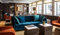 a living room with a blue couch and chairs at AMERON Hamburg Hotel Speicherstadt in Hamburg