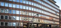a large brick building with a traffic light in front of it at AMERON Hamburg Hotel Speicherstadt in Hamburg