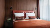 a bedroom with a large bed with an orange blanket at AMERON Hamburg Hotel Speicherstadt in Hamburg