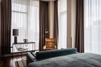 a bedroom with a bed and a chair and a window at AMERON Hamburg Hotel Speicherstadt in Hamburg