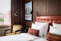 a hotel room with a bed and a chair and a window at AMERON Hamburg Hotel Speicherstadt in Hamburg