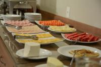 Un buffet con muchos tipos diferentes de comida en un mostrador. en Mont Blanc Suites Duque de Caxias, en Duque de Caxias