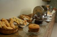 una encimera con cestas de pan y bollería en Mont Blanc Suites Duque de Caxias, en Duque de Caxias