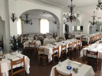 a dining room with white tables and chairs at Hotel Pineta in Ischia