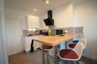 - une cuisine avec une table et des tabourets en bois dans l&#39;établissement Comme à la Maison - DE LA TOUR, à Saint-Quentin