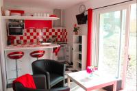 a kitchen with a black chair and a kitchen with red at Birchbank Cottage in Coulommiers