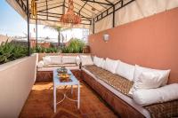 eine Couch auf einer Terrasse mit einem Tisch in der Unterkunft Riad Villa Harmonie in Marrakesch