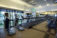 a gym with a row of treadmills and ellipticals at The Grand Hotel in Taipei