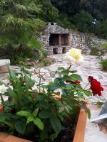 a garden with a stone building and a red flower at Gîte Acellu in Bonifacio