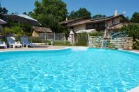 una piscina en un patio con 2 sillas y una casa en Gîte Bois et Senteurs, en Lafrançaise