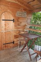 a wooden cabin with a table and a door at Les Ecolodges de l&#39;Orbière in Forcé