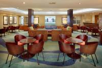um lobby de hotel com mesas e cadeiras em First Group Breakers Resort - Official em Durban