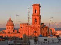 an old brick building with a clock tower at La Torre e il Mare Rooms by STHEY in Monopoli