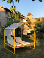 a yellow and white gazebo in a yard at Maison TANDEM in Cluny