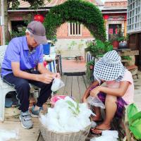 a man sitting next to a little girl with a basket at I-Shan B&amp;B in Jincheng