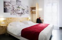 a bedroom with a large bed with a red blanket at hotel le beauséjour in Langogne