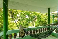 a hammock on a porch with trees in the background at Haadson Resort & Koh Raham in Haad Son
