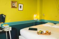 a yellow room with a bed with a tray on it at Hôtel Crayon in Paris