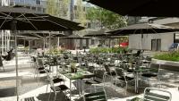 a group of tables and chairs with umbrellas at Placid Hotel Design & Lifestyle Zurich in Zürich