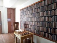 um tabuleiro de xadrez em frente a uma parede de livros em SmallFry's Beach Resort em Calatrava