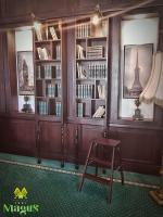 a room with a chair and book shelves with books at Magus Hotel in Baia Mare