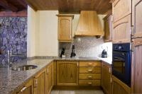 eine Küche mit Holzschränken und einer Spüle in der Unterkunft Apartaments Els Llacs in Bordes d´Envalira 