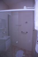 a glass shower in a bathroom with a sink at Pousada Mama África in Conservatória