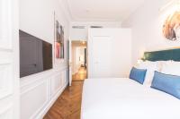 a bedroom with a large bed and a flat screen tv at Hôtel Alfred Sommier in Paris