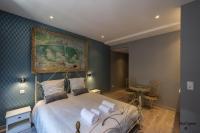 a bedroom with a bed with a painting on the wall at Cocoon amoureux de Beaune in Beaune