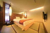 a hotel room with a bed and a television at CingYa Hot Spring Hotel in Baihe