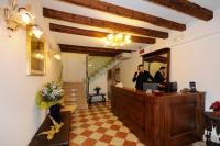 a man standing at a reception desk in a lobby at Hotel Il Mercante di Venezia in Venice