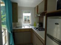 a kitchen with a sink and a stove and a window at Camping Aux Portes De Cassis in La Bédoule