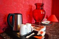 a table with a coffee maker and a red vase at Hotel Windsor Home in Paris