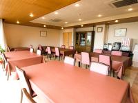 een restaurant met tafels en stoelen in een kamer bij LiVEMAX RESORT izukogen in Ito